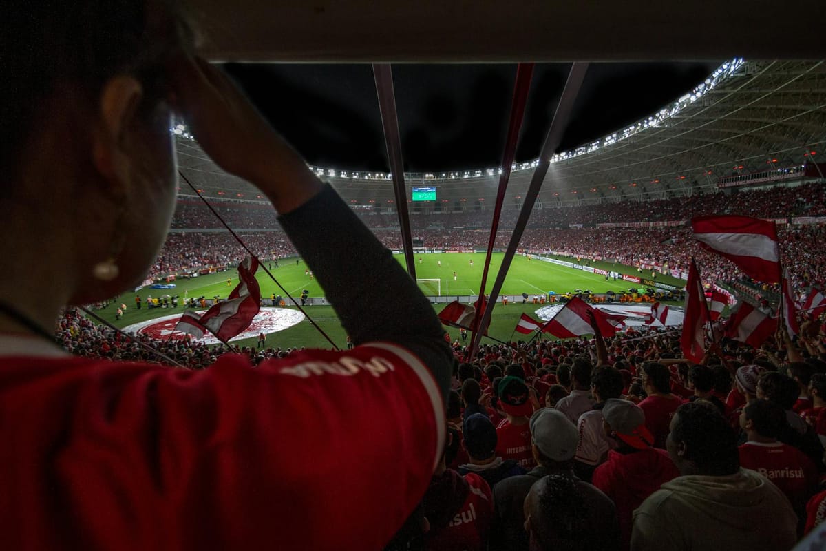 Lively soccer match at packed Brazilian stadium with cheering fans and vibrant atmosphere.